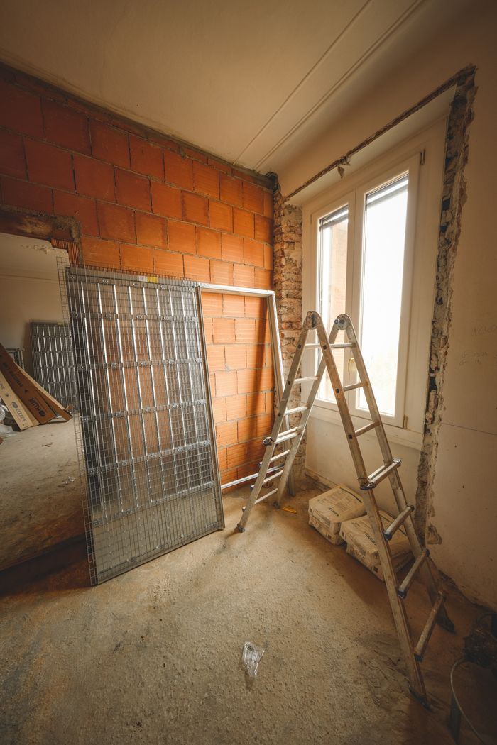 services-02 An indoor space showing ongoing refurbishment with ladders and construction materials.