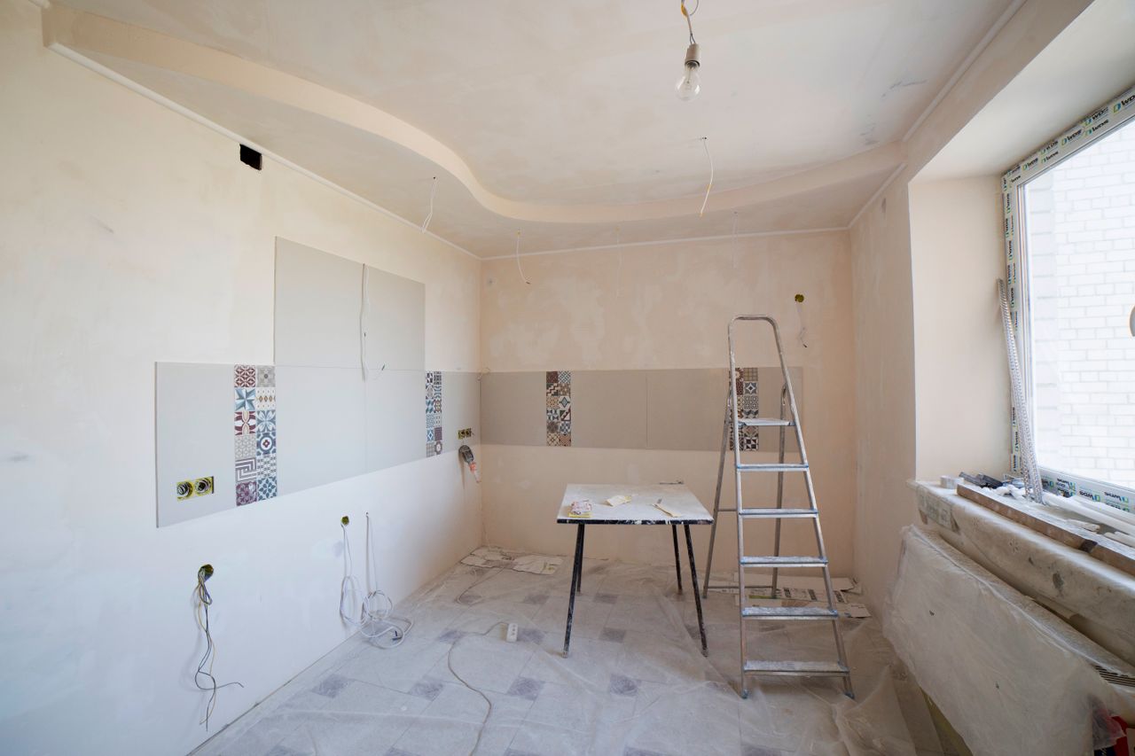 Mastering the First Impression: Your intriguing post title goes here Spacious kitchen under renovation with ladder and tools, showcasing a fresh new design.